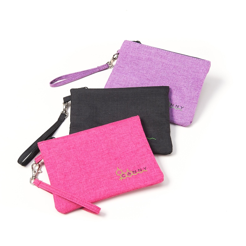 May include: Three zippered pouches in pink, black and purple with a gold embroidered logo that says "CANNY".