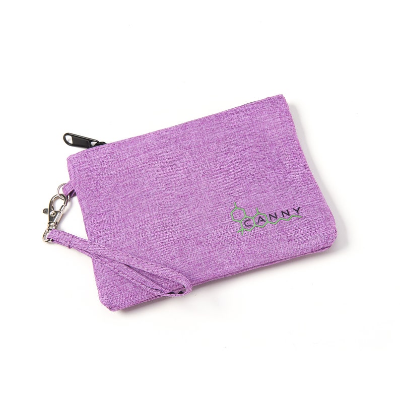 May include: A purple zippered pouch with a black zipper and a green and black logo that says "CANNY". The pouch has a purple strap.