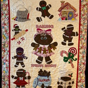 May include: A quilted wall hanging with a gingerbread theme. It features gingerbread people, a gingerbread house, a rolling pin, candy canes, and a jar of cookies. The text "Baking Spirits Bright!" is embroidered on the quilt.