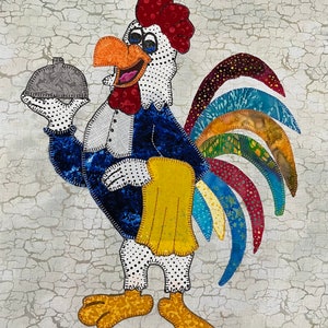 May include: A colourful rooster wearing a blue tuxedo and a yellow napkin, holding a silver cloche. The rooster has a red comb and wattle, a white face with black dots, and a multi-coloured tail.