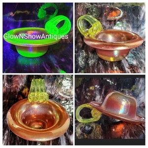 May include: A collection of iridescent glass objects, including a hat-shaped piece and a bowl with a handle. The objects have a warm, reddish-orange hue with a reflective surface. Some pieces glow bright green under UV light. The text "GlowNShowAntiques" is visible.