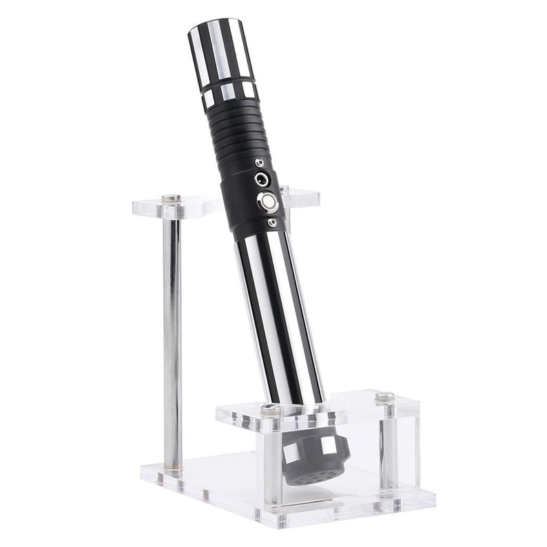 May include: A black and silver lightsaber with a clear acrylic stand. The lightsaber has a black handle with a silver blade and a black button on the side.