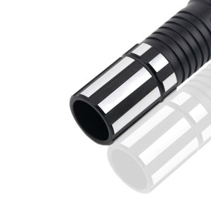May include: Close-up of the black and silver end of a lightsaber toy. The end of the lightsaber has a black plastic ring with silver stripes.