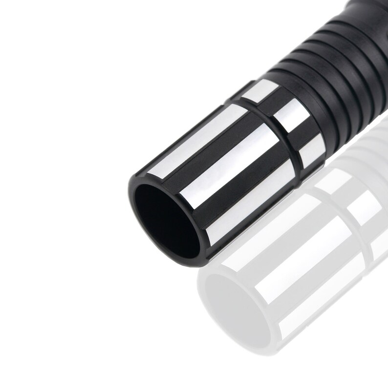 May include: Close-up of the black and silver end of a lightsaber toy. The end of the lightsaber has a black plastic ring with silver stripes.