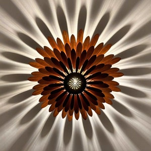 May include: A wooden ceiling light fixture shaped like a flower with brown petals and a central light source.