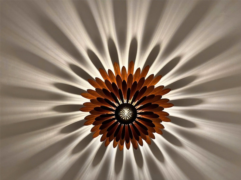 May include: A wooden ceiling light fixture shaped like a flower with brown petals and a central light source.