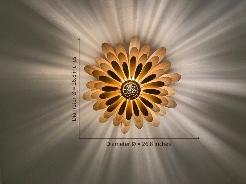 May include: A wooden ceiling light fixture shaped like a flower with 26.8 inch diameter. The light fixture has a warm, golden hue and is made of multiple layers of wood.