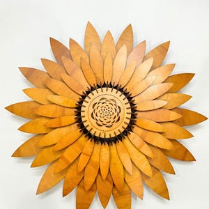 Puede incluir: Una gran decoraci&oacute;n de pared de girasol de madera con un centro detallado y m&uacute;ltiples capas de p&eacute;talos.