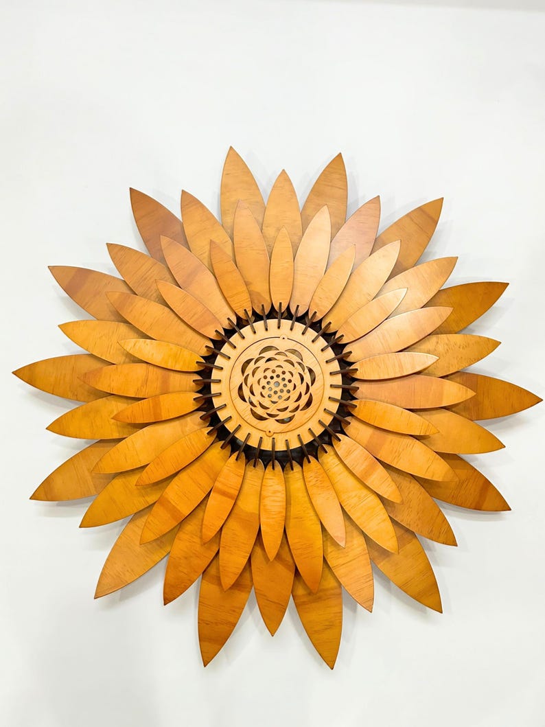 Puede incluir: Una gran decoraci&oacute;n de pared de girasol de madera con un centro detallado y m&uacute;ltiples capas de p&eacute;talos.