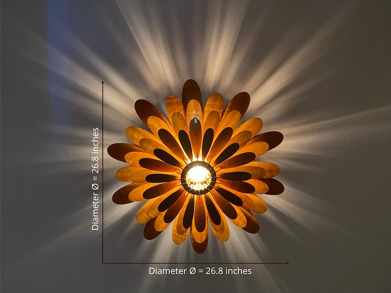 May include: A wooden ceiling light fixture shaped like a flower with a 26.8 inch diameter. The light fixture has a warm, golden brown colour and is made of many thin, overlapping wooden petals.