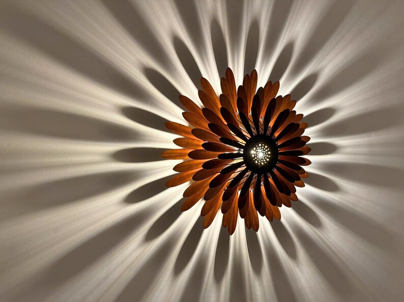 May include: A wooden ceiling light fixture shaped like a flower with brown petals and a central light source.