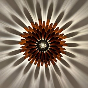 May include: A wooden ceiling light fixture shaped like a sunflower with brown petals and a central light source.