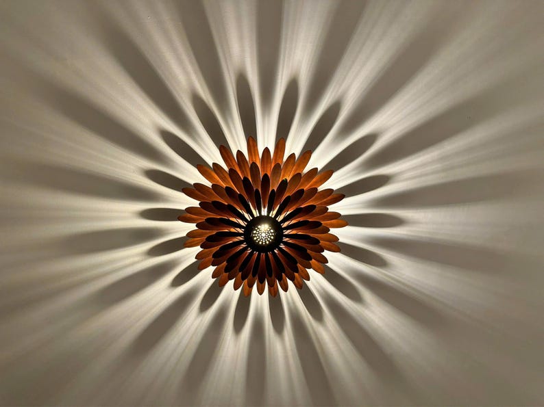 May include: A wooden ceiling light fixture shaped like a flower with brown petals and a central light source.