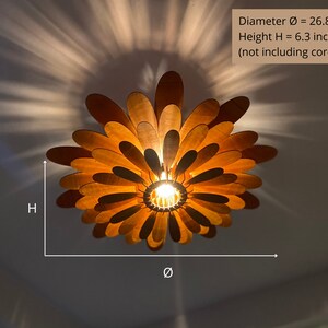 May include: A wooden ceiling light fixture shaped like a flower with multiple layers of petals. The light is on and the petals are illuminated. The fixture is 26.8 inches in diameter and 6.3 inches tall.
