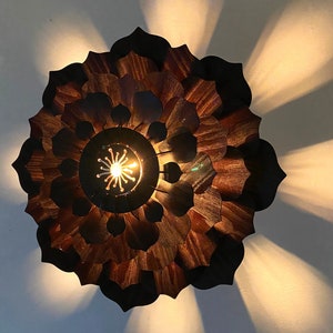 May include: A wooden flower-shaped ceiling light fixture with a brown finish and a central light bulb.