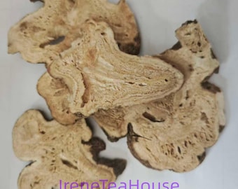 May include: Four dried, irregularly shaped slices of light tan root with a porous, fibrous texture and dark brown edges. The text IreneTeaHouse is printed in purple at the bottom of the image. The slices have a woody appearance with visible grain.