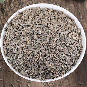 Puede incluir: Un bol blanco lleno de semillas secas marrones y grises. Las semillas son pequeñas y de forma ovalada.