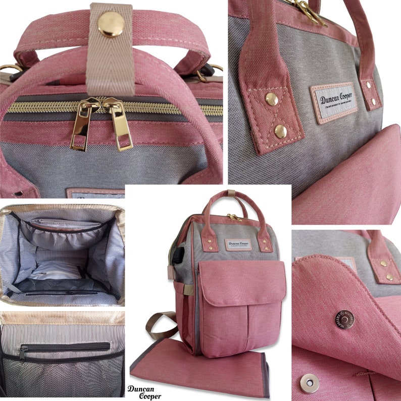 May include: A pink and gray diaper bag with a changing mat. The bag has a large main compartment, a front pocket, and two side pockets. The bag also has a zippered pocket on the front and a mesh pocket on the side. The bag has a handle on the top and adjustable straps. The bag is made of canvas and has a Duncan Cooper logo on the front.