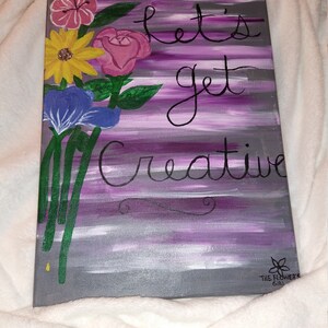 Pode incluir: Uma pintura em tela listrada em roxo e cinza com um buquê de flores e o texto "Let's get creative". A pintura é assinada "The Flower Girl" no canto inferior direito.
