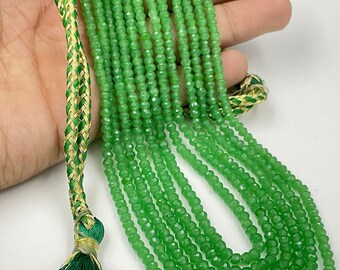 Peut inclure: Un brin de perles de pierres précieuses facettées vertes avec un pompon vert et or. Les perles sont enfilées sur un cordon fin et mesurent environ 4 mm de diamètre.