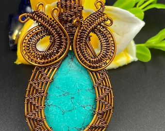May include: A turquoise gemstone pendant with a copper wire wrapped design. The pendant is shaped like a teardrop and has a woven wire pattern around the stone.