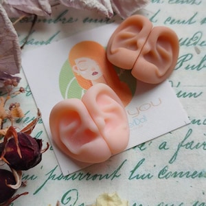 Può includere: Due paia di orecchie scolpite realistiche, color carne. Le orecchie sono fatte di pasta polimerica e sono progettate per la creazione di bambole. Le orecchie sono su uno sfondo bianco con un biglietto scritto a mano che dice "You erDoll"