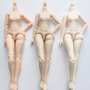 May include: Three nude-colored articulated doll bodies with no heads. The dolls are posed with their legs crossed and their arms bent at the elbows. The dolls are all the same size and have the same body type.