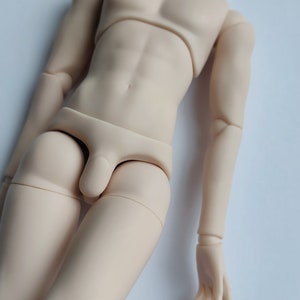 May include: A nude-colored doll body with jointed limbs and a simple underwear garment.