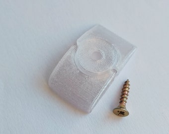Może przedstawiać: Biały plastikowy uchwyt ścienny z okrągłym otworem w środku i złotą śrubą.