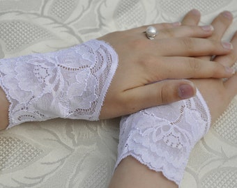 Puede incluir: Un par de puños de encaje blanco con un patrón floral. Los puños están hechos de encaje delicado y tienen un aspecto suave y femenino.