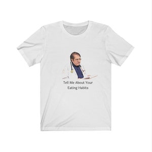 Może przedstawiać: Biała koszulka z nadrukiem mężczyzny w białym fartuchu lekarskim i stetoskopem. Pod obrazkiem znajduje się napis "Tell Me About Your Eating Habits".