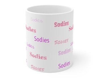 Peut inclure: Une tasse en céramique blanche avec le nom "Sodies" répété en lettres roses et violettes.
