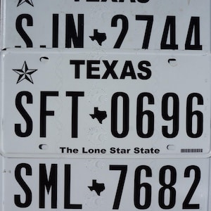 May include: Three white Texas license plates with black lettering. The top plate reads "S.IN-2744", the middle plate reads "SFT-0696", and the bottom plate reads "SML-7682". Each plate has a small star and the state of Texas in the upper left corner and the words "The Lone Star State" at the bottom.