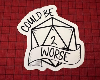 May include: White sticker with a black and white illustration of a 20-sided die with the number 2 showing. A banner below the die reads "Could Be Worse".