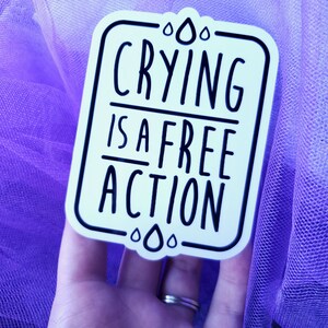 May include: White sticker with black text and raindrop designs. The text reads "Crying is a free action."