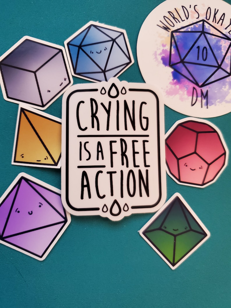 May include: A set of nine colorful stickers featuring cartoon dice with faces. The stickers are on a teal background. One sticker says "Crying is a free action". Another sticker says "World's Okay DM".