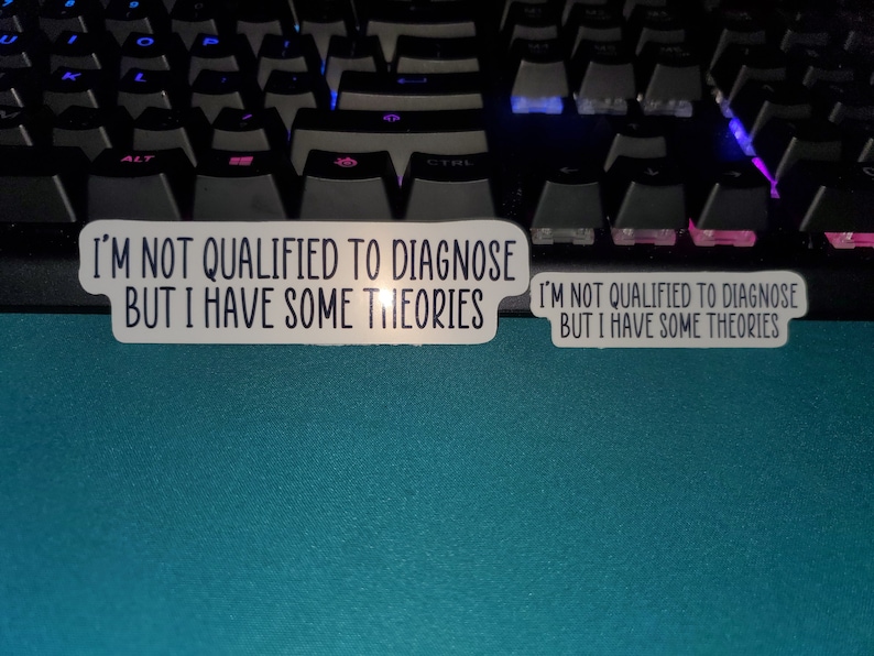 May include: Two white stickers with black text on a blue surface. The text on the stickers reads "I'm not qualified to diagnose but I have some theories."