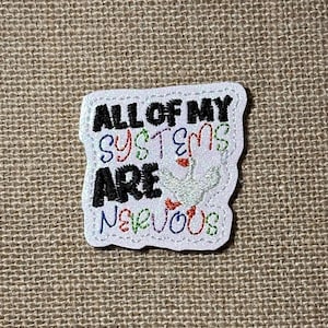 May include: A white embroidered patch with a glittery finish featuring the black text ALL OF MY and the word ARE, with the words SYSTEMS and NERVOUS in multi-colored outline embroidery, plus a small white goose icon with an orange beak.