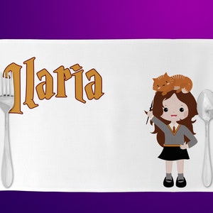 Può includere: Tovaglietta bianca con il nome "Ilaria" in lettere dorate. Un'illustrazione a cartoni animati di una ragazza in uniforme scolastica con un gatto sulla testa è a destra. Una forchetta e un cucchiaio sono su entrambi i lati della tovaglietta.