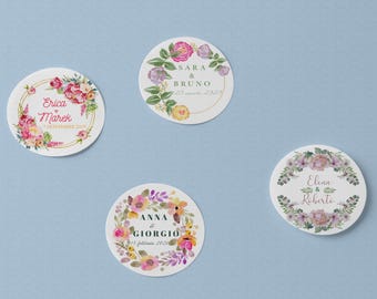May include: Four round floral stickers with names and dates. Each sticker features a watercolor floral wreath design in shades of pink, purple, and yellow. The stickers have names and dates in the center.