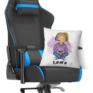 Può includere: Una sedia da gioco nera con accenti blu e un cuscino bianco con una ragazza dei cartoni animati che indossa cuffie e tiene un controller per videogiochi. Il cuscino ha il nome "Laura" stampato su di esso.