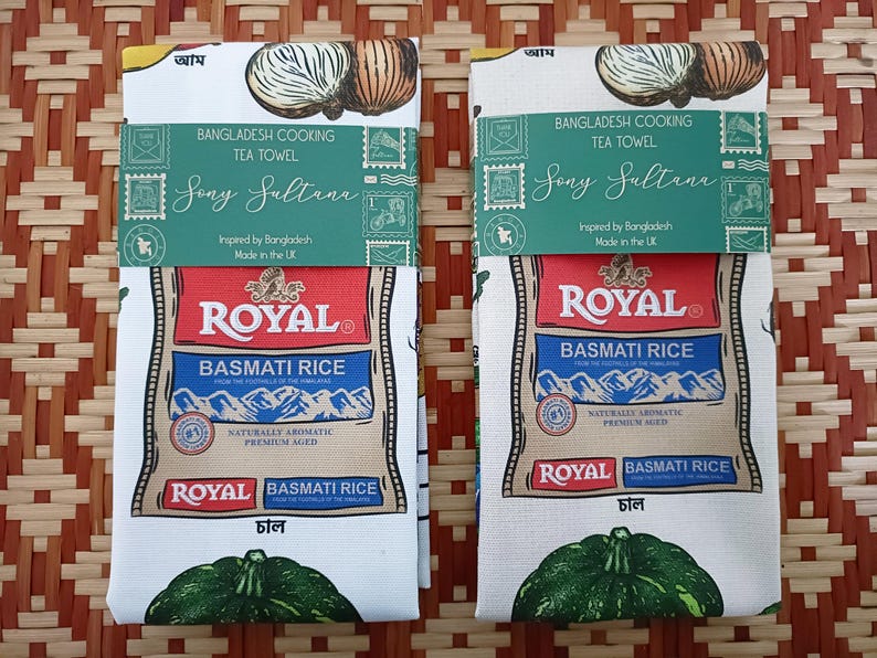 May include: Two tea towels with a white background, featuring a design of onions, green squash, and text. The towels are labeled "Bangladesh Cooking Tea Towel" and "Royal Basmati Rice". The text "Sony Sultana" is also visible.