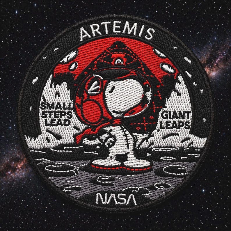 May include: Embroidered patch featuring Snoopy in an astronaut suit on a lunar surface. The patch has the word "ARTEMIS" at the top, with "SMALL STEPS LEAD" and "GIANT LEAPS" on either side of Snoopy. The NASA logo is at the bottom.