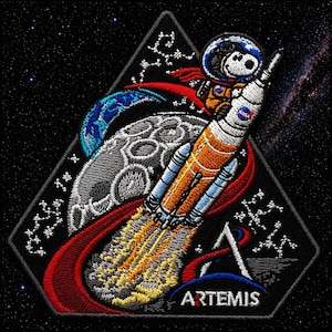 May include: Embroidered patch featuring Snoopy in an astronaut helmet riding a rocket ship, with the NASA logo. The patch includes a depiction of the moon, Earth, and the word "ARTEMIS" at the bottom, all set against a starry background.