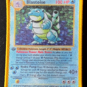 以下が含まれることがあります： 1999 年のオリジナルポケモンカードゲームセットからの青と緑のブラストイズポケモンカード。カードは、中央にブラストイズの画像が描かれた青い背景になっています。カードは白い枠線があり、上部に黒い文字で「ブラストイズ」と書いてあります。カードには、右上の隅に赤い文字で「HP100」と書いてあります。カードは、中央にブラストイズの画像が描かれた青と白の背景になっています。カードは白い枠線があり、上部に黒い文字で「ブラストイズ」と書いてあります。カードには、右上の隅に赤い文字で「HP100」と書いてあります。