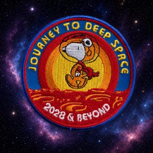 May include: A circular embroidered patch featuring a white cartoon dog in an orange spacesuit against a yellow sun and red planet surface. The blue border contains the yellow text JOURNEY TO DEEP SPACE and 2028 & BEYOND in white lettering.