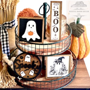 May include: A two-tiered wire rack with a wooden base, decorated with Halloween-themed signs. The signs feature ghosts, pumpkins, bats, and the word "Spooky".