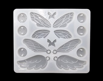 Può includere: Stampo in silicone bianco con più cavità per la creazione di gioielli in resina. Lo stampo presenta due set di ali d'angelo, due set di ali di farfalla e quattro piccoli cerchi.