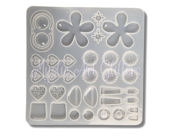 Può includere: Uno stampo in silicone trasparente con varie forme per il fai-da-te. Lo stampo include disegni floreali, fiocchi, cuori e geometrici, perfetto per resina o altri progetti fai-da-te. Lo stampo è rettangolare e si trova su una superficie bianca.