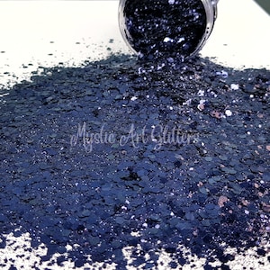 May include: A close-up of a pile of dark blue glitter with a hint of silver and copper. The glitter is spilling out of a jar.